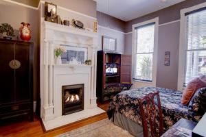 a living room with a fireplace and a bed at Azalea Inn and Villas in Savannah