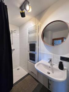 a white bathroom with a sink and a mirror at Woody Cabin in Buttelstedt