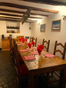 a long wooden table with red flowers on it at Chalet Jora - Total Chalets in Bansko