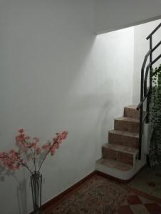 una escalera con un jarrón con flores en una habitación en Zia Ciccia en Marsala