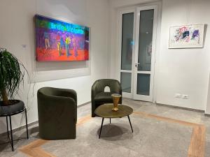 a living room with two chairs and a table at Soul Art Hotel in Naples