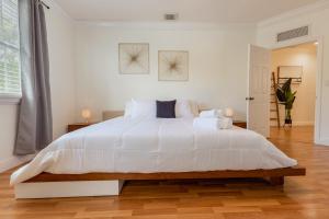 een witte slaapkamer met een groot bed met witte lakens bij Miami Luxury Villa Heated Pool & Pool Table 5BD 4BR in Miami