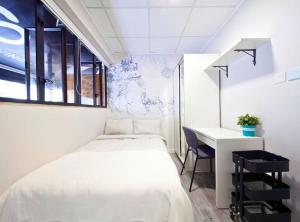 a small bedroom with a bed and a desk at Pillows CoLiving in Hong Kong