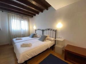 1 dormitorio con 1 cama con sábanas blancas y almohadas azules en Norabona Cangas de Onís VUT-3104-AS, en Cangas de Onís