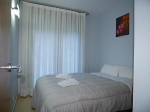 a bedroom with a bed with white sheets and a window at Saüc-Vacances Pirinenca in Canillo