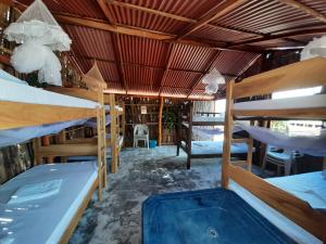 a room with several bunk beds and a hot tub at Talata Hostal in Mayapo