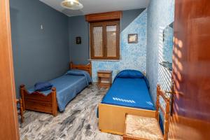 two beds in a room with blue walls at La Vecchia Cascina in Atena Lucana