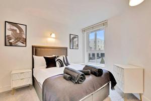 a bedroom with a bed and a large window at Radiant 2BR Tower Bridge Oasis with Rooftop Deck in London