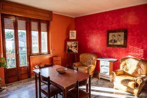 a living room with red walls and a table and chairs at La Vecchia Cascina in Atena Lucana
