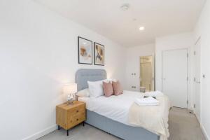 a bedroom with a bed and a table with a lamp at Central 2BR Urban Haven Rooftop Terrace in Bracknell