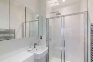 a white bathroom with a sink and a shower at Central 2BR Urban Haven Rooftop Terrace in Bracknell