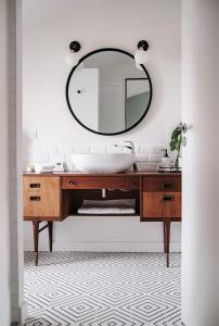 La salle de bains est pourvue d'un lavabo et d'un miroir. dans l'établissement 64 Sur Le Mail, à La Rochelle