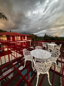 un grupo de mesas y sillas blancas en un balcón en BALCÓN DEL CIELO eco hotel glamping, en Frailes