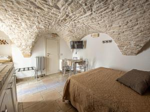 a bedroom with a bed and a table in a room at Martine Dimore Storiche di Puglia in Martina Franca