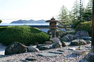 um jardim japonês com uma fonte e rochas em Villa SHINOBI -忍- em Hinase