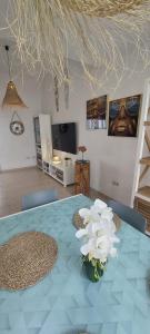 een tafel met daarop een vaas met bloemen bij Villa Dinateli, Salinas Golf in Caleta De Fuste
