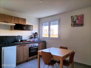 a kitchen with a table and a small kitchen with a table and chairs at 2 SDB - 2 Chambres - 1 lit d'appoint enfants in Montaigu-Vendée