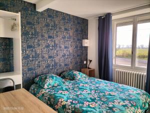 um quarto com uma cama com colcha floral e uma janela em 2 SDB - 2 Chambres - 1 lit d'appoint enfants em Montaigu-Vendée