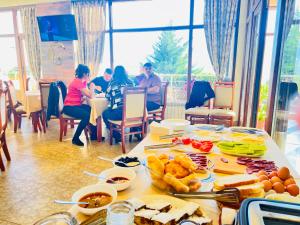 una mesa con comida y gente sentada en un restaurante en ArdoVel Park Hotel, en Velingrad