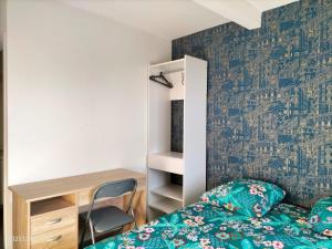 um quarto com uma cama e uma secretária em 2 SDB - 2 Chambres - 1 lit d'appoint enfants em Montaigu-Vendée