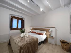 a white bedroom with a bed and a window at Can Carisma in Camprodon
