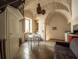 a living room with a table and a kitchen at Martine Dimore Storiche di Puglia in Martina Franca