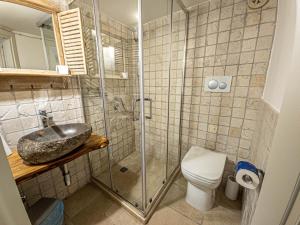 a bathroom with a shower and a sink and a toilet at Martine Dimore Storiche di Puglia in Martina Franca