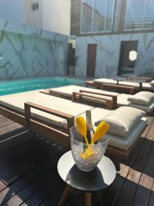 uma tigela de flores numa mesa ao lado de uma piscina em Santorini Beach Hotel em Arraial d'Ajuda