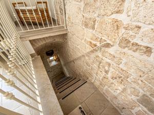 a staircase in a building with a stone wall at Martine Dimore Storiche di Puglia in Martina Franca