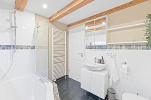 een witte badkamer met een wastafel en een douche bij Moderne Altbauwohnung im Zentrum Ludwigsburg - Kingsize Bett - Netflix in Ludwigsburg