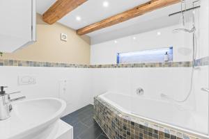 a white bathroom with a tub and a sink at TOP Apartments - Moderne Altbauwohnung im Zentrum Ludwigsburg - Kingsize Bett - Netflix - 80qm - 24h Check-In in Ludwigsburg