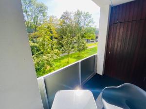 Zimmer mit Balkon und Blick auf die Bäume in der Unterkunft Schönes Wohnen in Groß-Buchholz - Zentral+Modern in Hannover