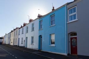 eine Reihe von blauen und weißen Häusern auf einer Straße in der Unterkunft Family Home with Bunk Beds, Courtyard, TV & Beach in Pembrokeshire