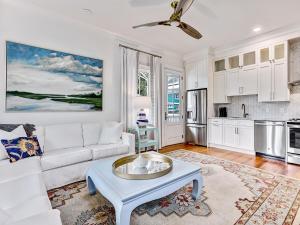 a living room with a white couch and a table at Amazing stay with beach access and heated pool, walking to restaurants, bars, and shopping in Tybee Island