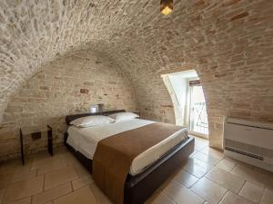 a bedroom with a large bed in a brick wall at Martine Dimore Storiche di Puglia in Martina Franca