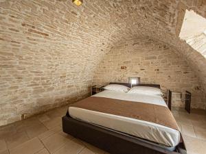 a bedroom with a bed in a brick wall at Martine Dimore Storiche di Puglia in Martina Franca