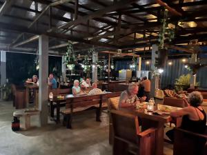 a group of people sitting at tables in a restaurant at Sutopia Holiday Resort in Meerzorg