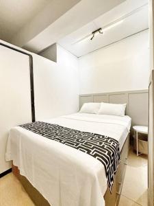 ein Schlafzimmer mit einem Bett mit einer schwarzen und weißen Decke in der Unterkunft Easy White Beach Access, with Kitchen, Dining and Living Room, Perfect for Groups and Family in Boracay