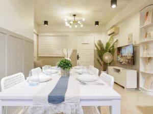 a white dining room with a white table and white chairs at Easy White Beach Access, with Kitchen, Dining and Living Room, Perfect for Groups and Family in Boracay