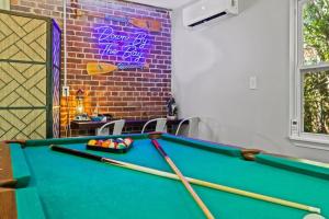 a pool table in a room with a sign at Down By The Bay w Hot Tub, 2 Blocks 2 Beaches, Game Room, Reading Nook, Dog-Friendly, Historic Charm in Panama City