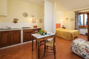 a kitchen with a table and a bed in a room at Agriturismo Fattoria Santo Stefano in Greve in Chianti