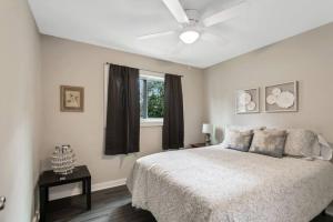 a bedroom with a bed and a ceiling fan at Cozy Cumberland ATL Home w Hot Tub in Atlanta