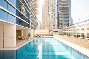 a swimming pool on the roof of a building with tall buildings at Marina One Bedroom - KV Hotels in Dubai