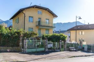 ein Haus mit einem Zaun davor in der Unterkunft Casa Maggiorina, Levico Terme Ospitar in Levico Terme