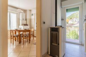 eine Küche und ein Esszimmer mit einem Tisch und Aussicht in der Unterkunft Casa Maggiorina, Levico Terme Ospitar in Levico Terme