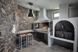 eine Küche mit einer Steinmauer und einem Backofen in der Unterkunft Akrotiri Private Residence in Fira