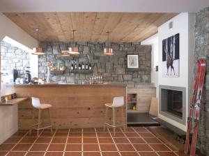 a kitchen with a bar with a stone wall at Hotel Le Chalet in Sainte-Marie-de-Campan