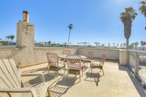 a patio with a table and chairs and palm trees at Sunny Imperial Beach Condo - Walk to Ocean! in Imperial Beach