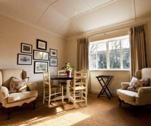 a living room with a table and chairs at Roodenburg House in Cape Town