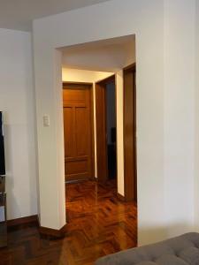 um quarto vazio com uma porta e um piso de madeira em Luxury Apartment Barranco Malecon em Lima